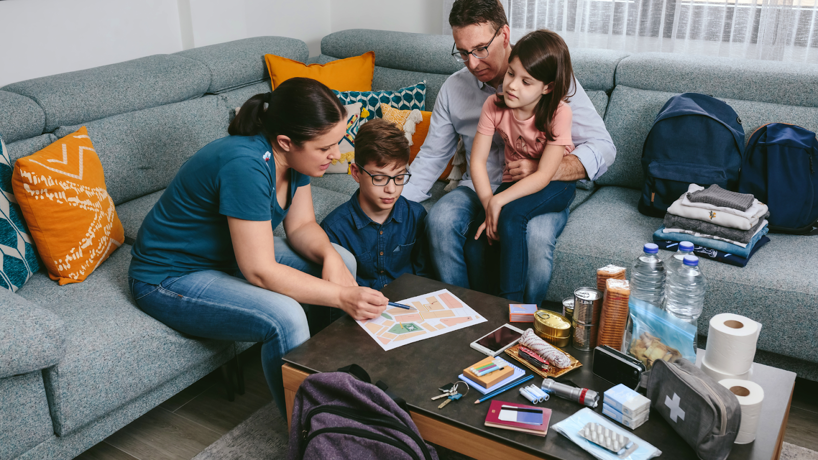 Family reviewing flood emergency plan with supplies laid out