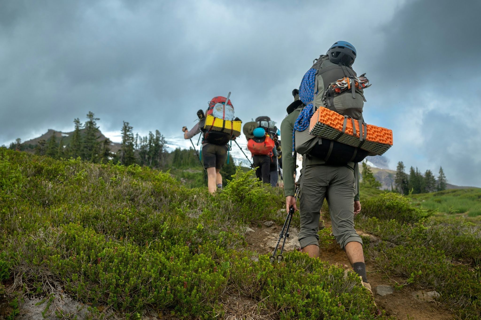 Group of Hikers with Full Backpacks Climbing a Mountain